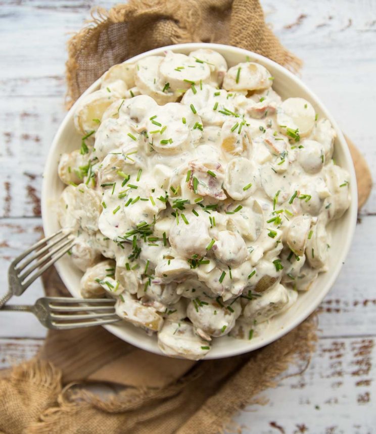 overhead shot of bowl of potato salad with two silver forks resting on it