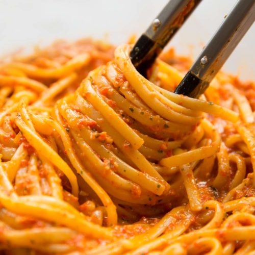 pasta tongs twirling in a bowl of linguine