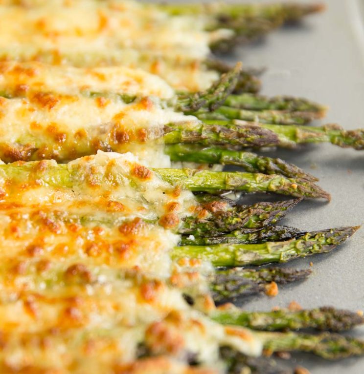 cheesy asparagus fresh out the oven on silver baking tray