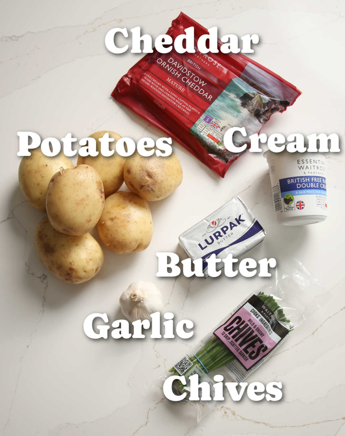 overhead shot of cheesy garlic mash ingredients with text labels