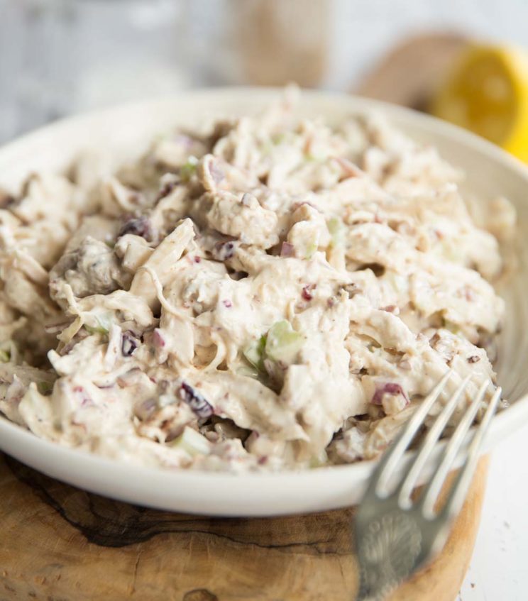 chicken salad in a white bowl with silver fork resting on it