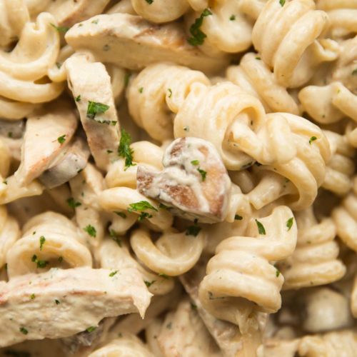 overhead shot of chicken and mushroom pasta with parsley to garnish