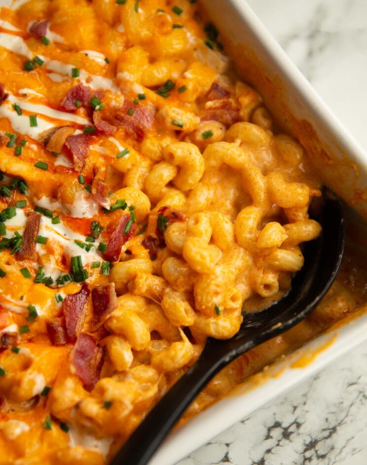 close up shot of serving spoon digging in to baked buffalo chicken mac and cheese fresh out the oven