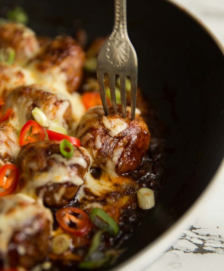 fork stabbing into skillet of meatballs