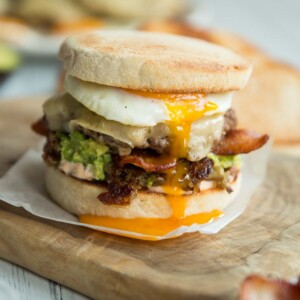 breakfast burger with yolk dripping down on chopping board