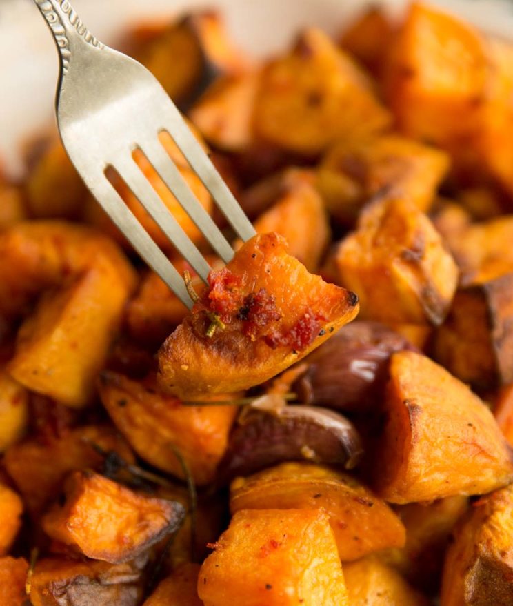 fork digging into sweet potato on baking tray