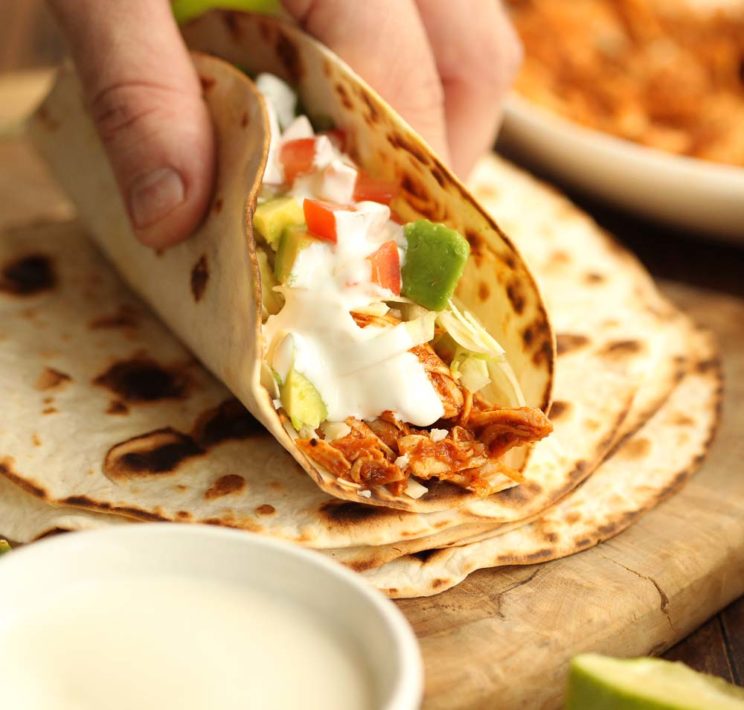 closeup of turkey taco with ingredients blurred in background