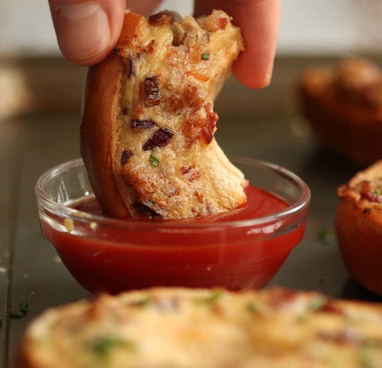 dipping quiche bagel into tomato sauce