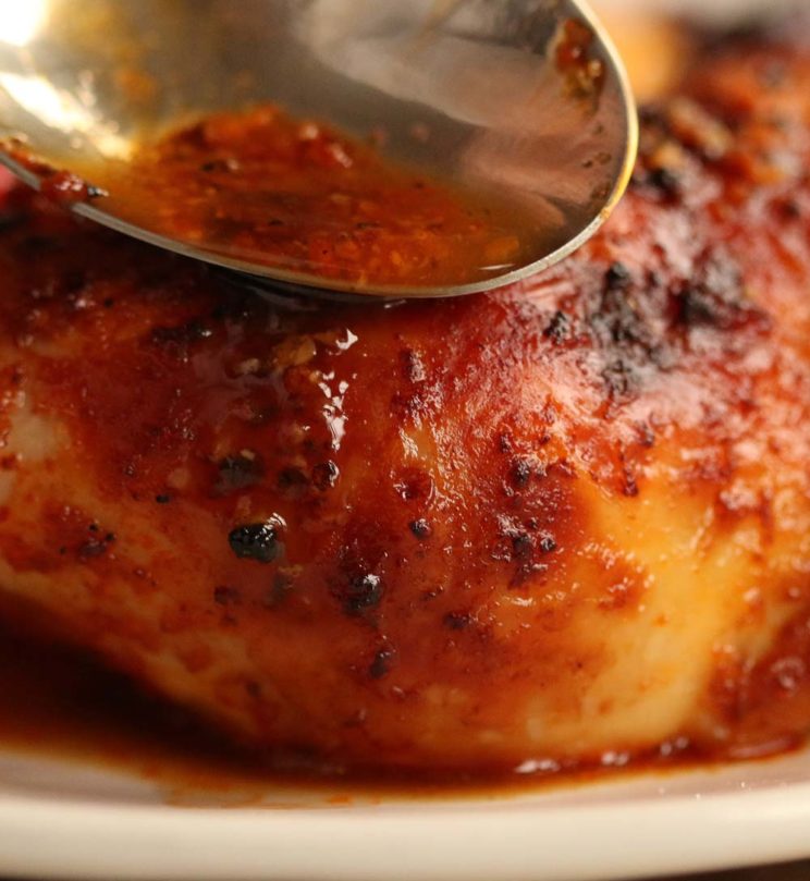 closeup of spooning over juices on chicken leg