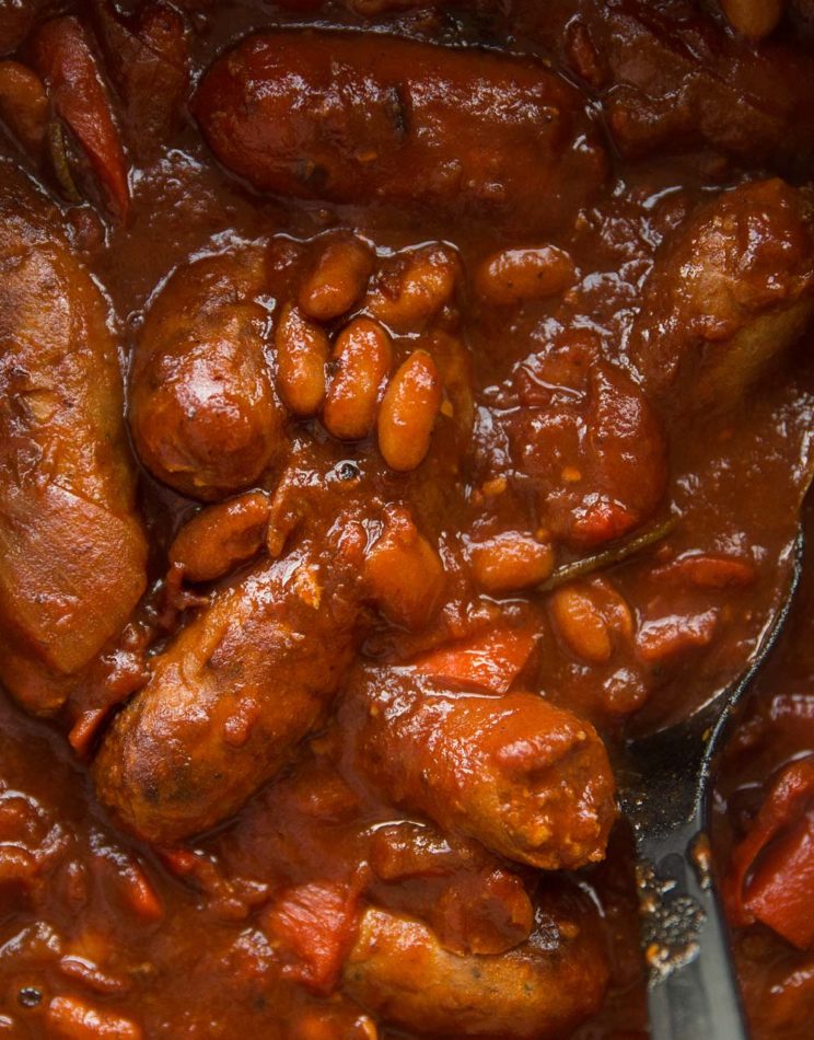 overhead shot of sausage casserole in pot with serving spoon digging in