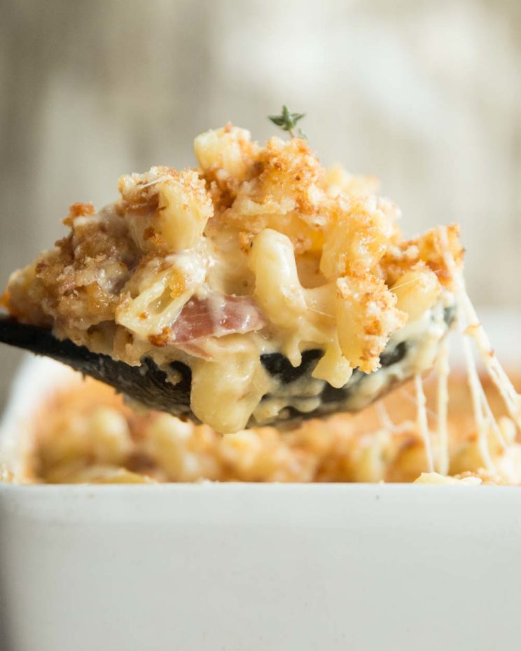 large spoonful of mac and cheese scooped out of baking dish