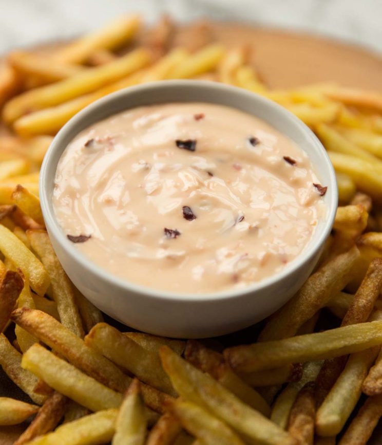 closeup shot of sweet chilli mayo in pot surrounded by fries