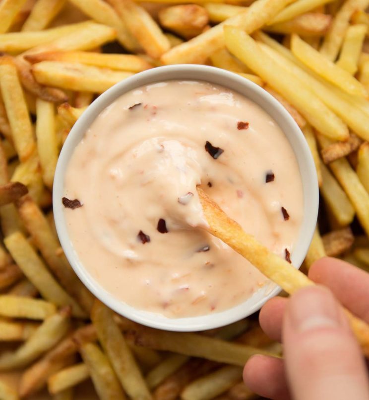 overhead shot of sweet chilli mayo dipping a fry into it
