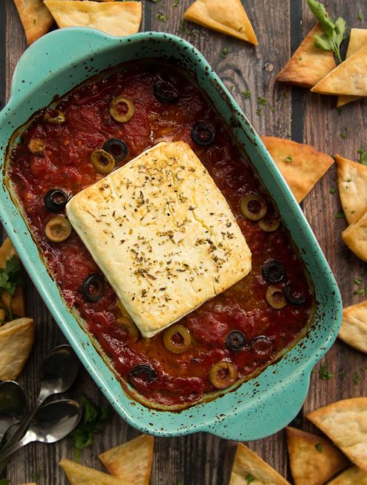 overhead shot of baked feta fresh out the oven surrounded by pita chips