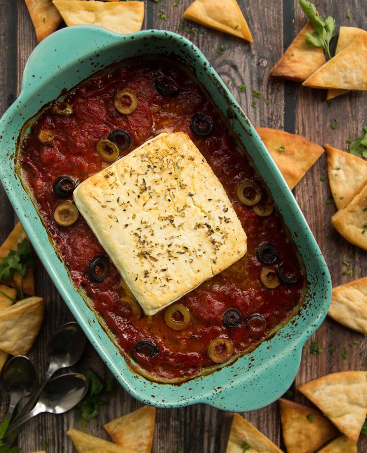 overhead shot of baked feta fresh out the oven surrounded by pita chips