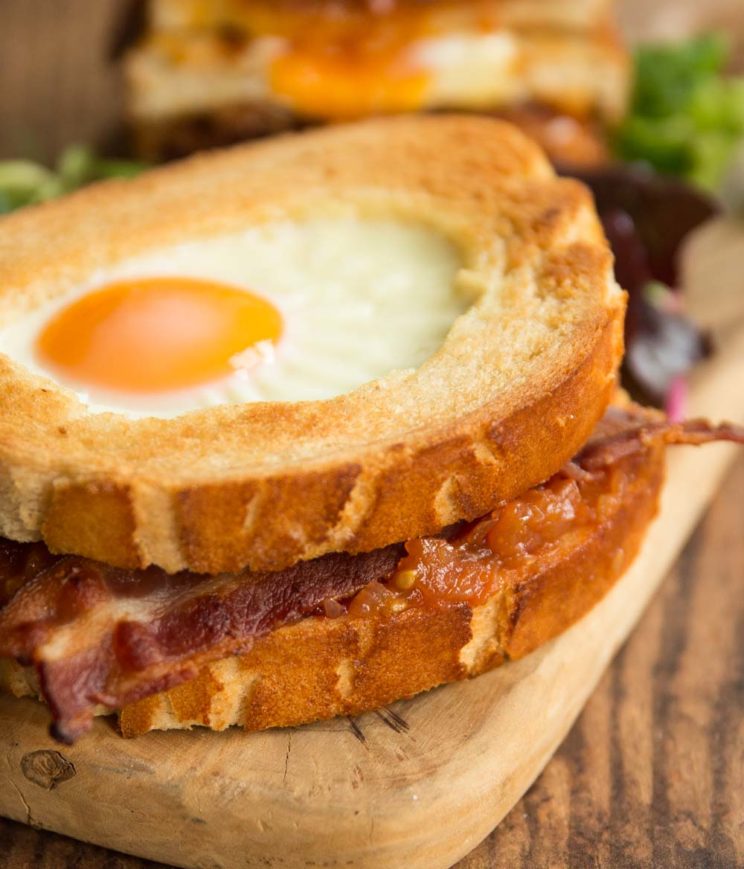 closeup shot of bacon sandwich on wooden board 