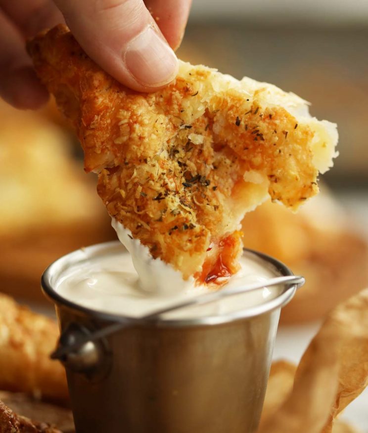 dipping pepperoni pizza pocket into dip