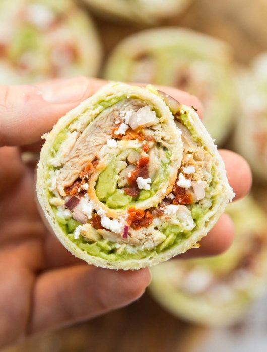 closeup shot of chicken avocado pinwheel with more blurred in the background