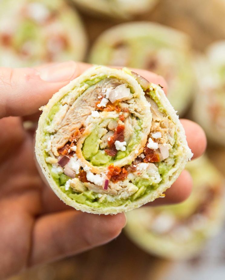 closeup shot of chicken avocado roll up with more blurred in the background