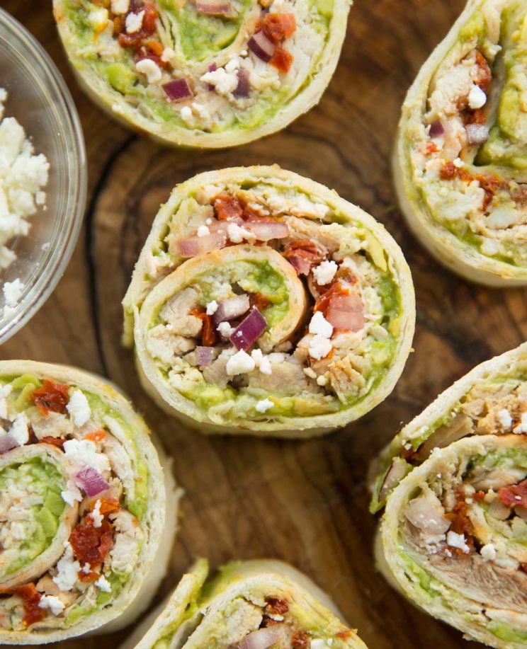overhead shot of avocado chicken roll ups on wooden board