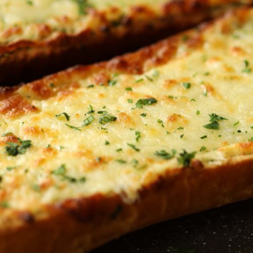 cheesy garlic bread fresh out the oven garnished with parsley