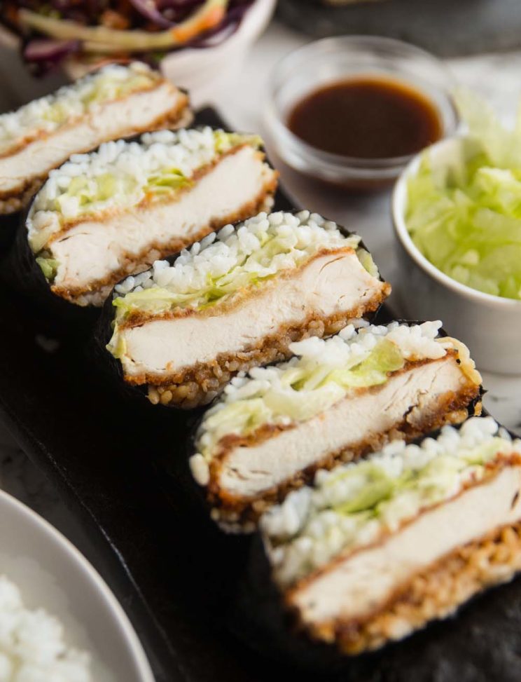 sushi sandwiches stacked on long plate with garnish surrounding