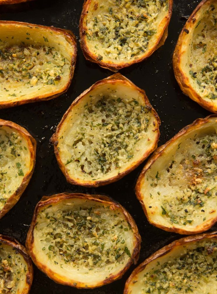 overhead shot of potato skins scattered on black baking tray