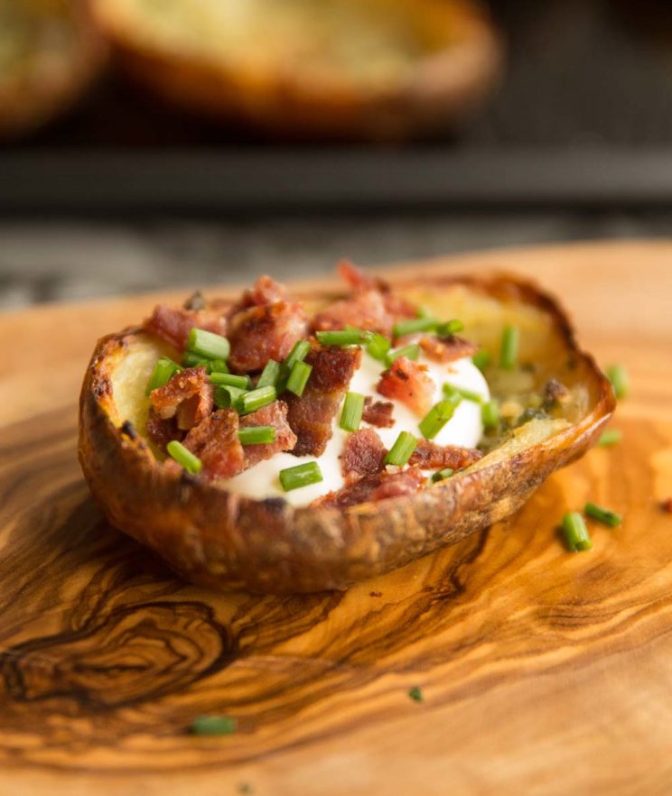 close up shot of loaded potato skins on chopping board