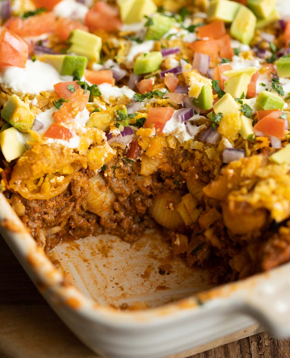 closeup shot of taco pasta in casserole dish with portion scooped out