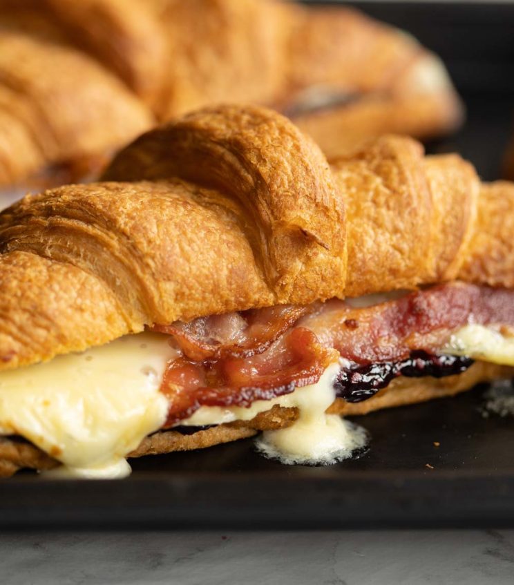 closeup shot of croissants fresh out the oven with brie dripping out
