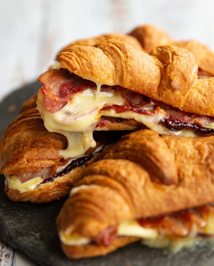 croissants stacked on one another with brie dripping off of top one