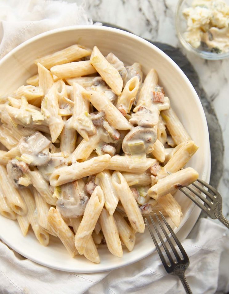 overhead shot of pasta in white bowl with two forks resting on it