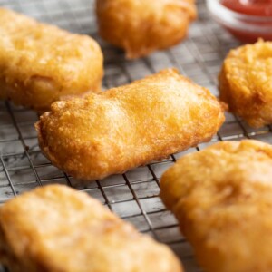 fritters fresh out the fryer on wire rack with ketchup blurred in background