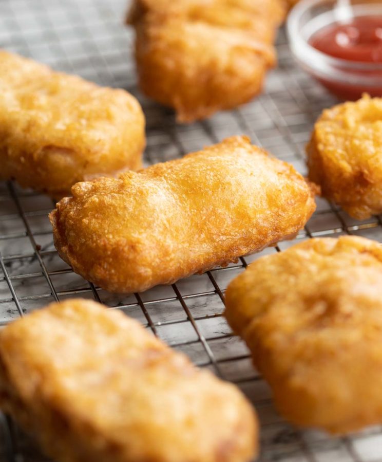 fritters fresh out the fryer on wire rack with ketchup blurred in background
