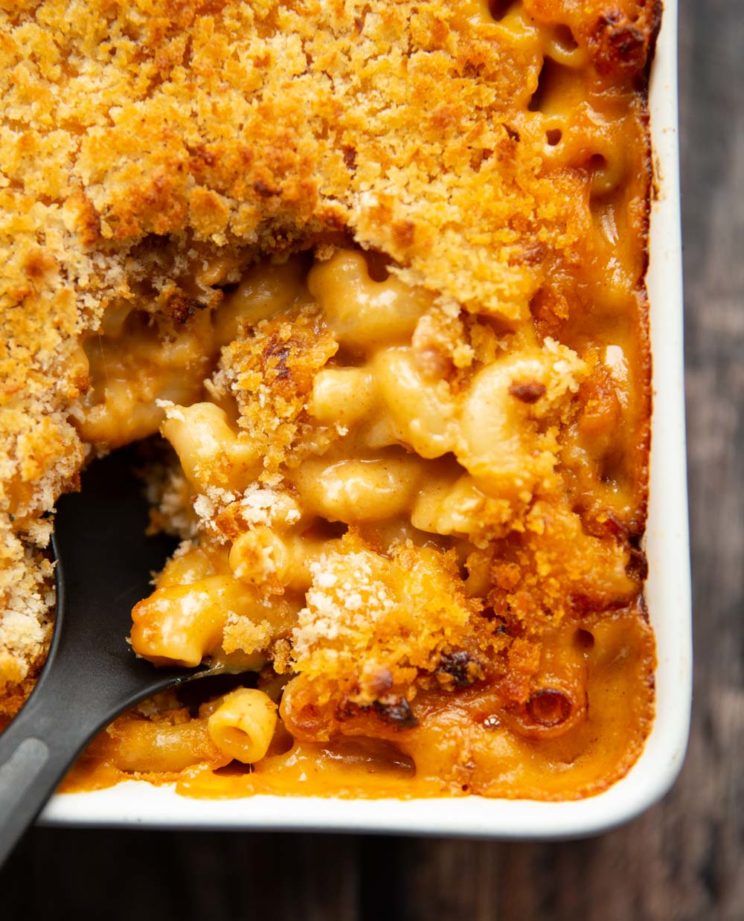overhead shot of serving spoon digging into mac and cheese