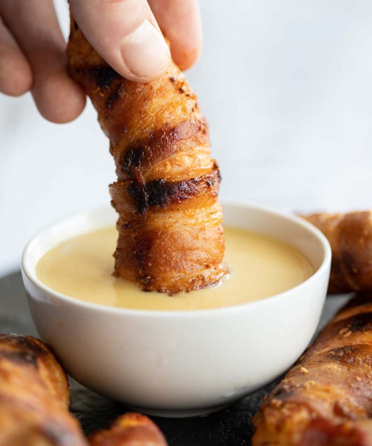 hand dunking tender into dip in small white pot