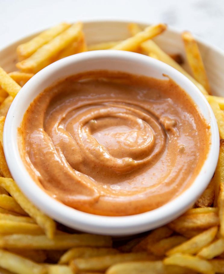 white pot with mayo inside surrounded by french fries