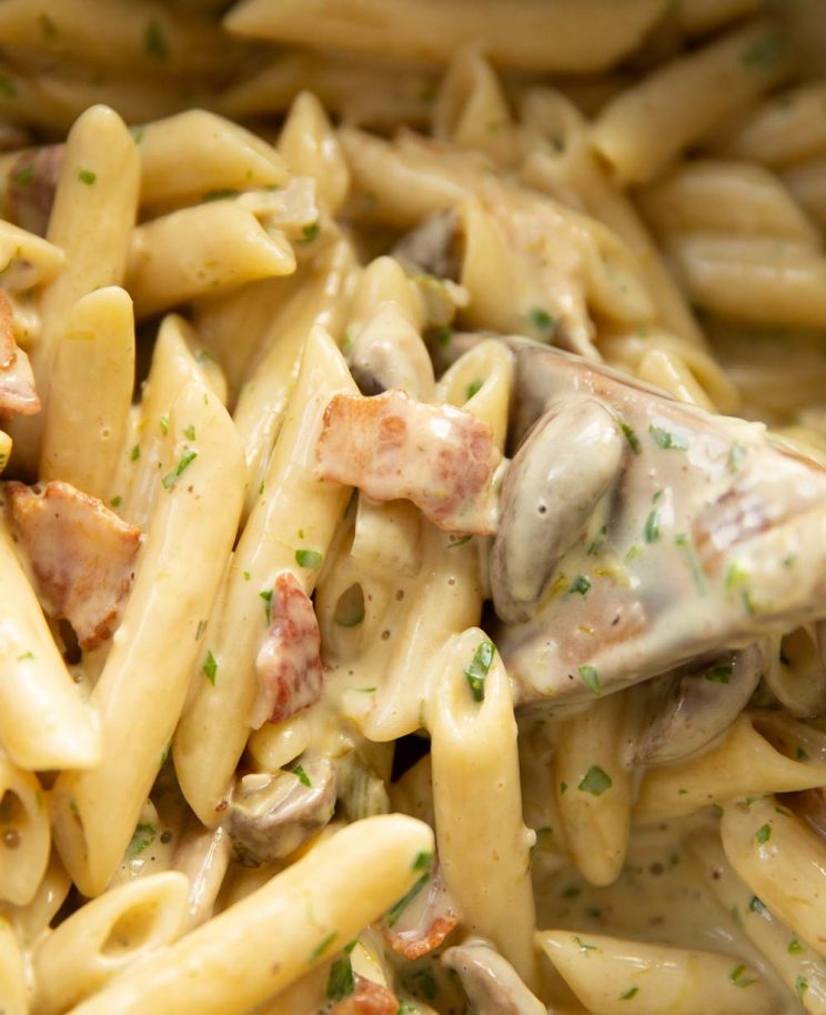 closeup shot of pasta in pot with focus on bacon