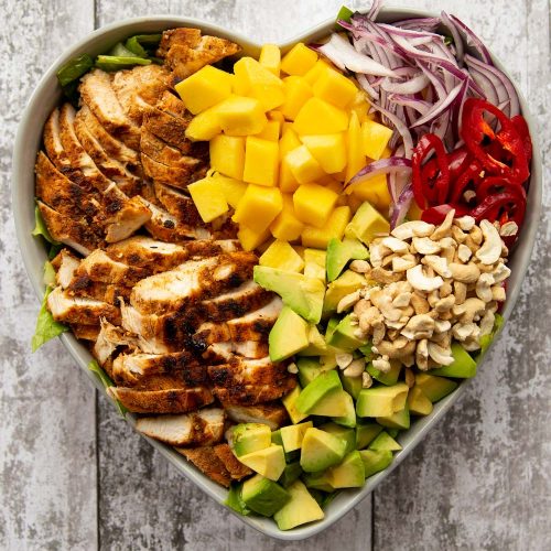 overhead shot of salad served in a heart shaped bowl