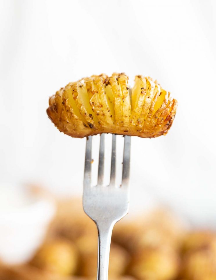 mini potato on end of fork with white background