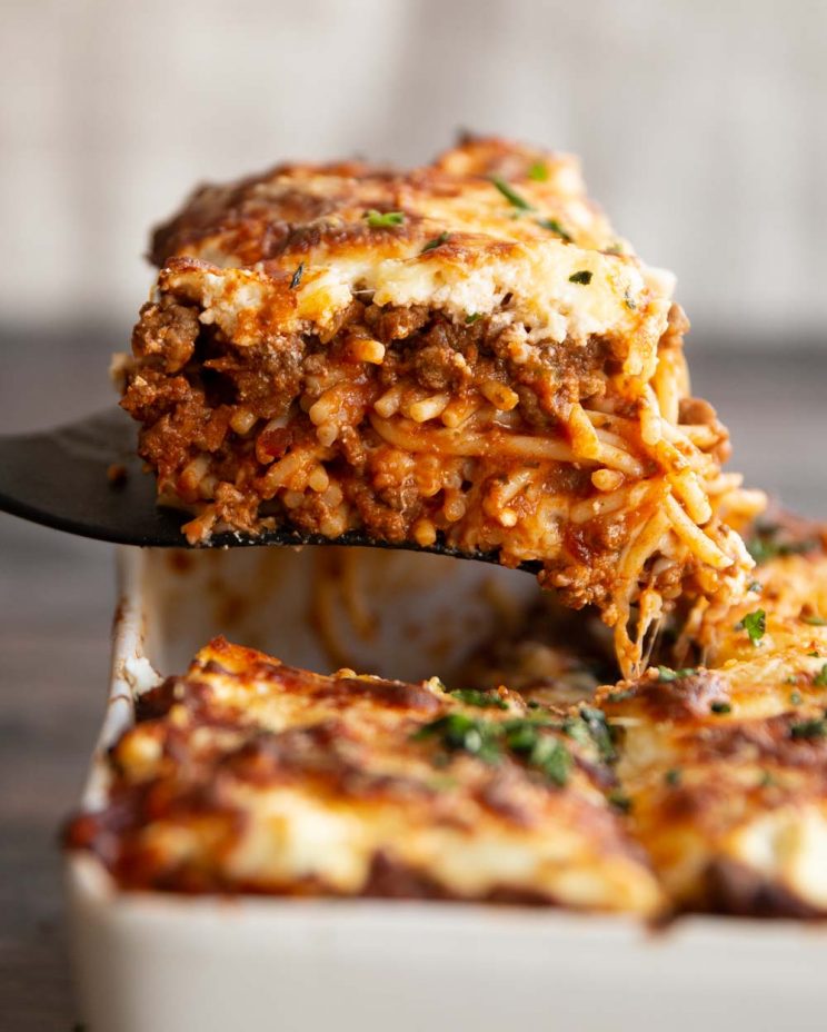 spatula lifting spaghetti from casserole dish