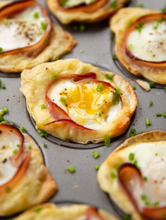 closeup shots of egg cups in muffin tin garnished with chives