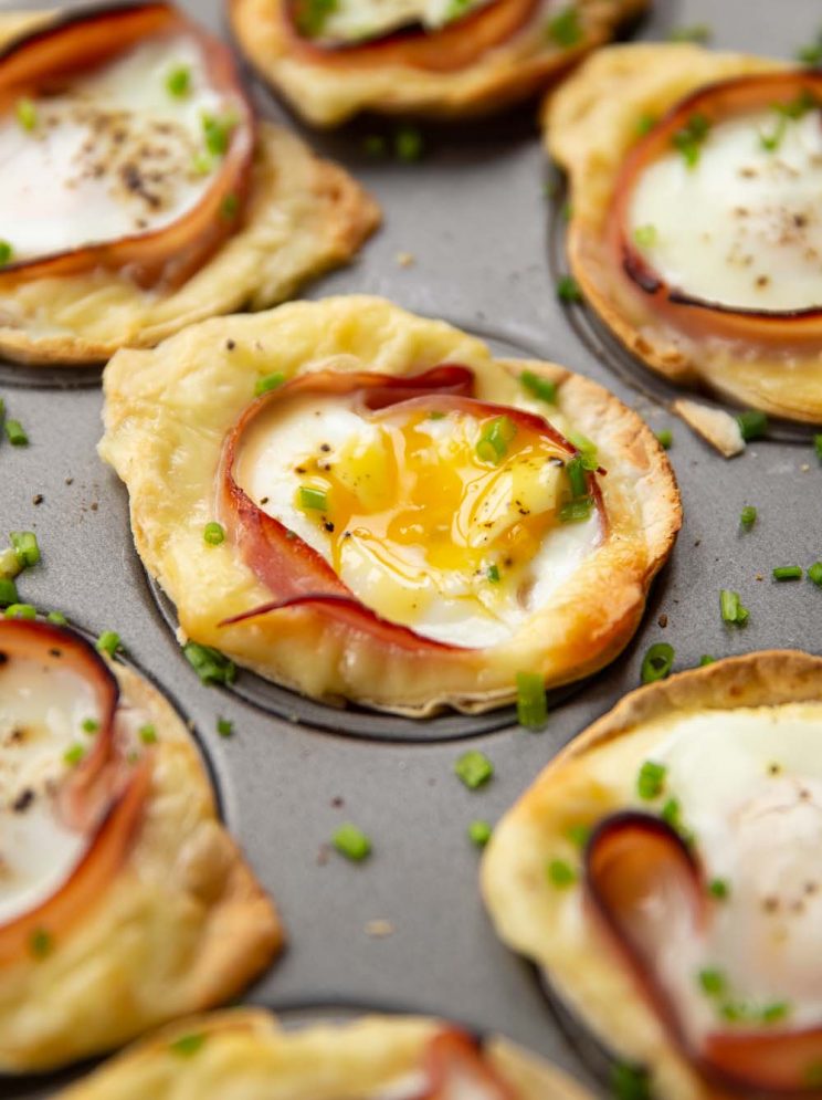 closeup shots of egg cups in muffin tin garnished with chives