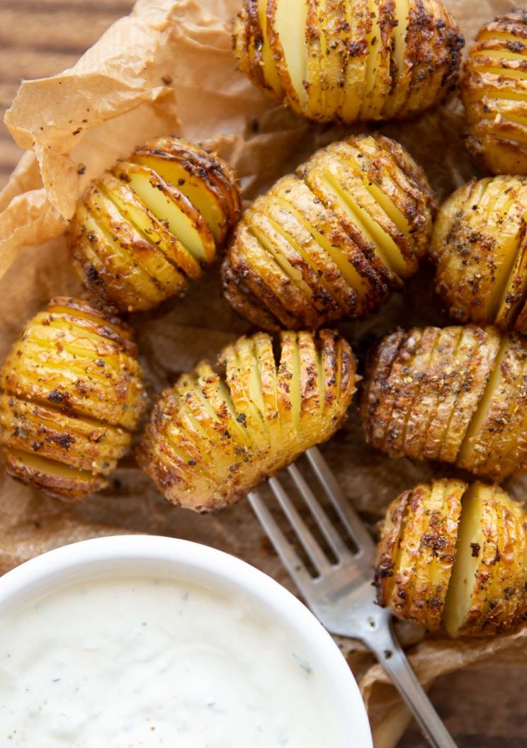 overhead shot of potatoes on brown parchment paper with dip in corner
