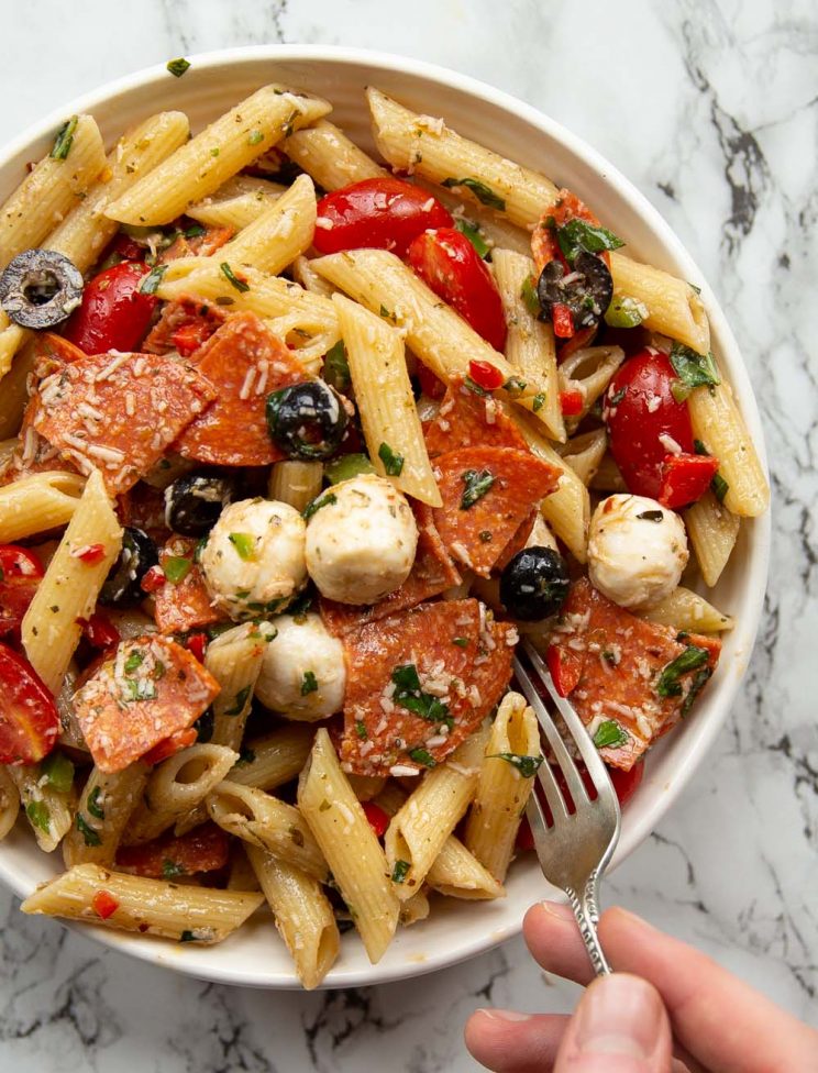 overhead shot of hand digging fork into pasta