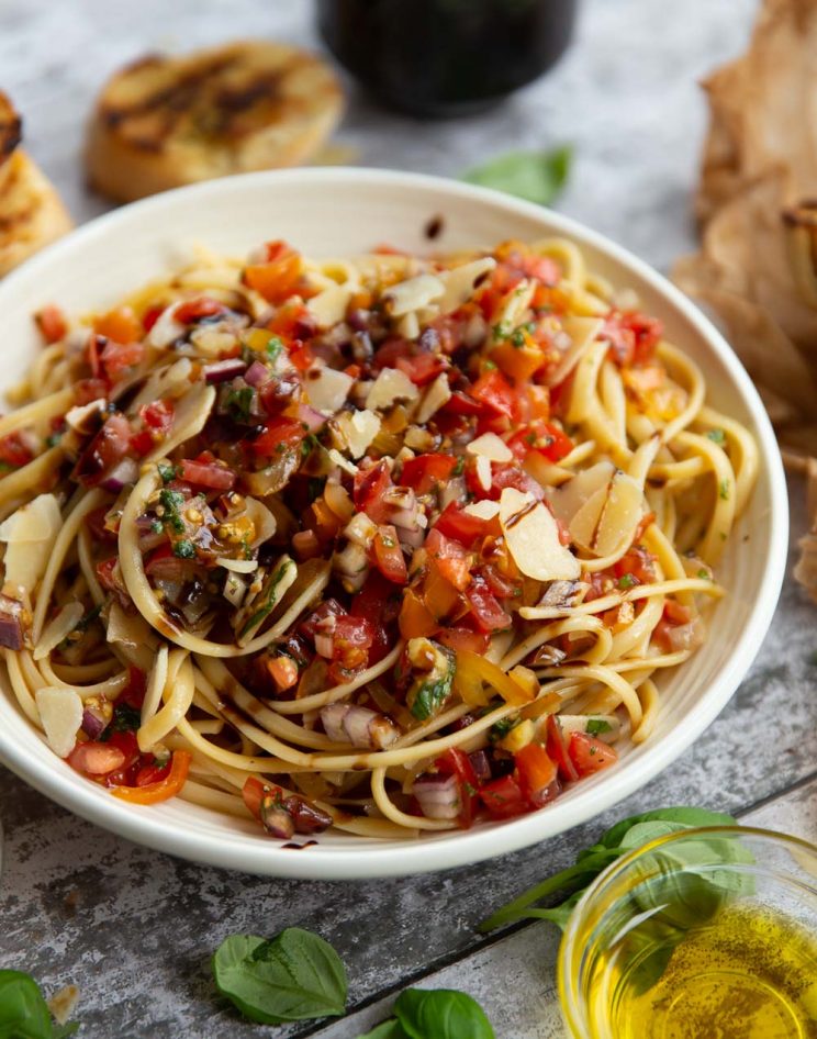 pasta served in white bowl surround by garnish