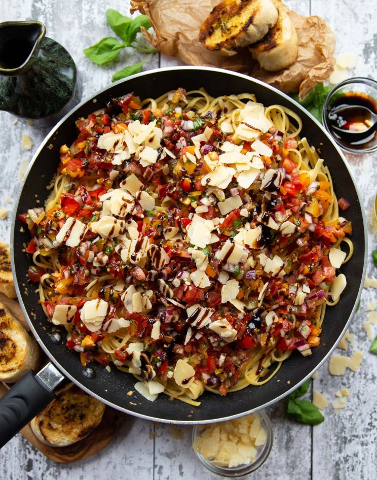 overhead shot of pasta in skillet surround by garnish