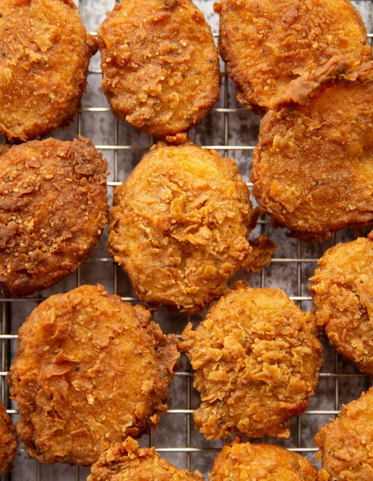 overhead shot of deep fried potatoes on wire rack fresh out the fryer