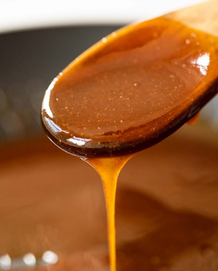 closeup shot of sauce dripping off of wooden spoon