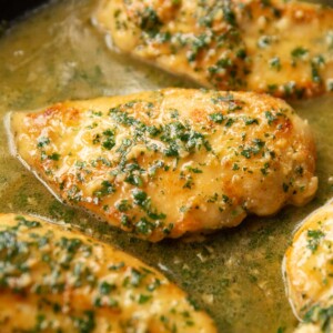 close up shot of chicken in skillet garnished with parsley